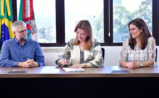 Hoelzl, prefeita Fátima e secretária Roberta durante a assinatura no Centro Administrativo Leopoldo Petry — Crédito:
Lu Freitas/PMNH